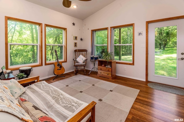 bedroom featuring multiple windows, wood finished floors, vaulted ceiling, and baseboards