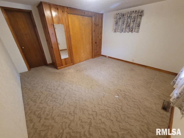 unfurnished bedroom featuring carpet floors and baseboards