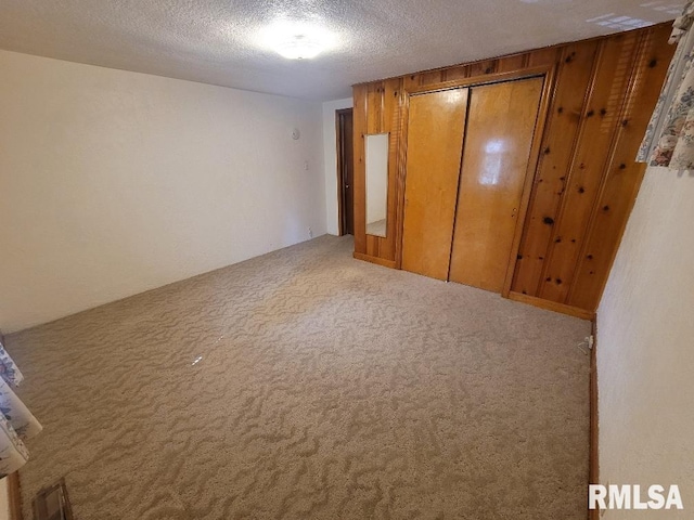 unfurnished bedroom featuring carpet flooring, a closet, and a textured ceiling