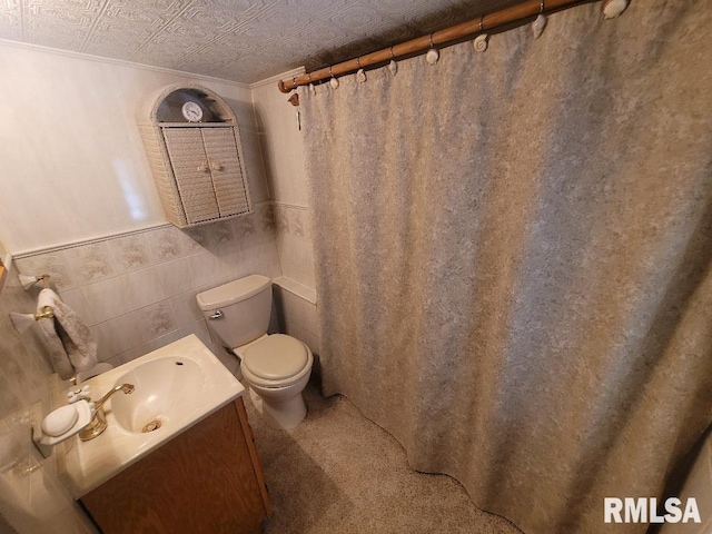 full bath featuring toilet, vanity, curtained shower, an ornate ceiling, and wainscoting