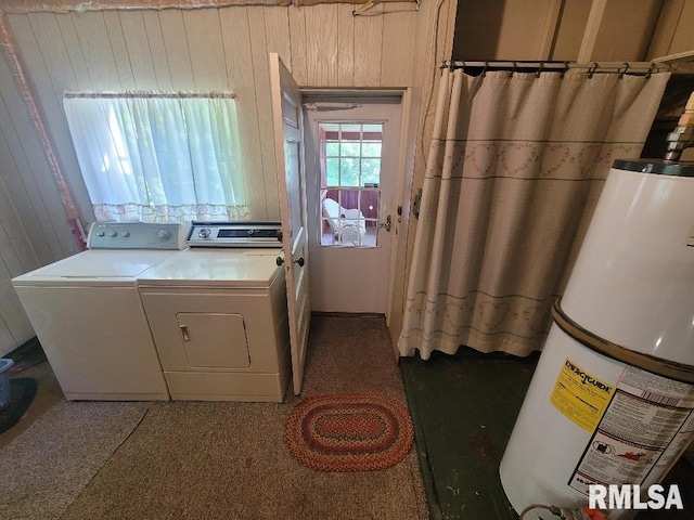 laundry room featuring gas water heater, separate washer and dryer, and wood walls