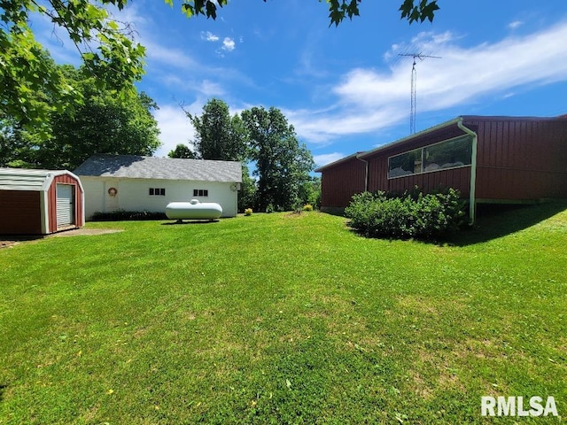 view of grassy yard with an outbuilding and a storage shed