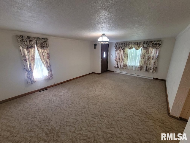 carpeted spare room featuring a textured ceiling, a baseboard heating unit, crown molding, and baseboards