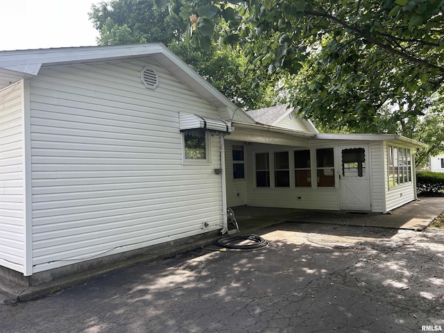 401 W 11th St, Christopher, IL 62822 - view of home's exterior with a patio area, a sunroom, and a shingled roof