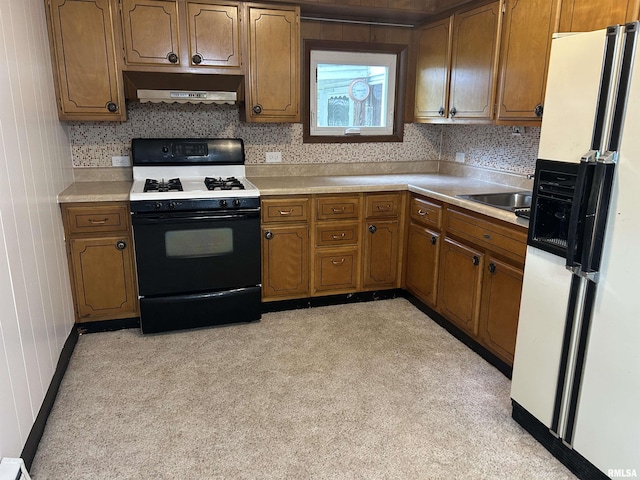 401 W 11th St, Christopher, IL 62822 - kitchen featuring range with gas cooktop, extractor fan, white refrigerator with ice dispenser, a sink, and light countertops