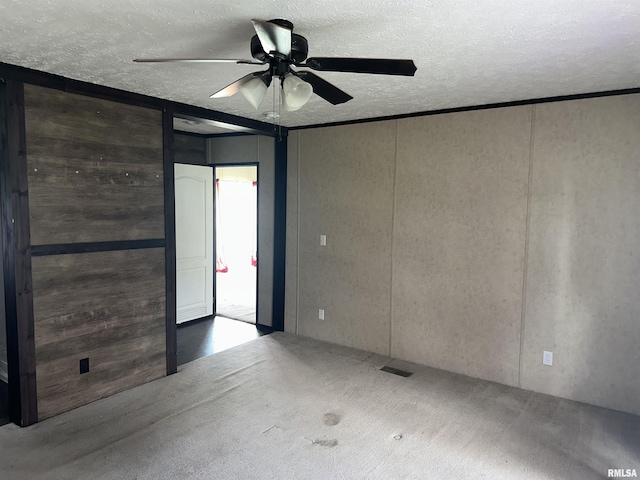 unfurnished room featuring a ceiling fan, a textured ceiling, and carpet flooring