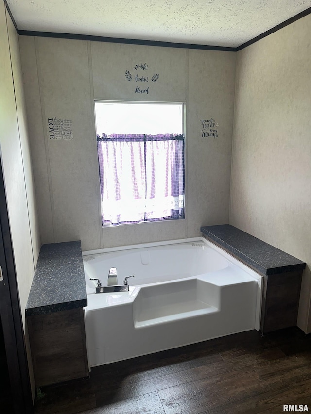 full bath with a garden tub, wood finished floors, a textured wall, and a textured ceiling