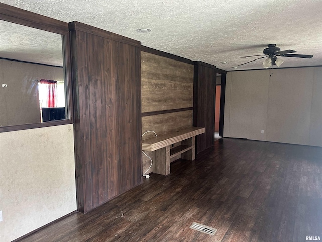 spare room with a textured ceiling, a ceiling fan, and wood finished floors