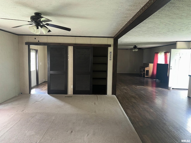 unfurnished living room with ceiling fan, a textured ceiling, and wood finished floors