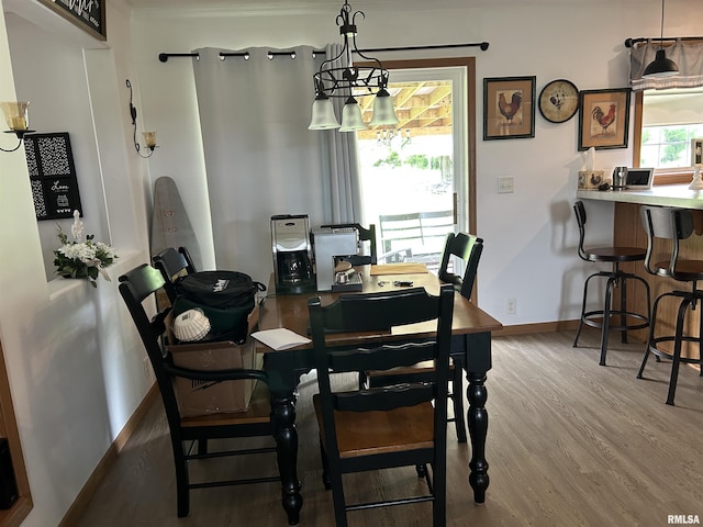 dining area featuring wood finished floors, baseboards, and a chandelier