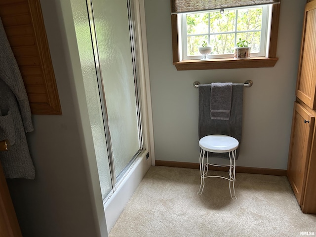 full bath with a shower with door, baseboards, and carpet floors