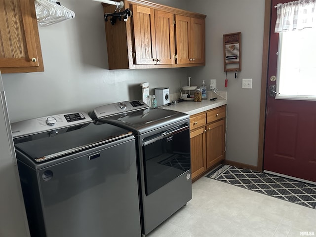 laundry area with cabinet space, washer and dryer, and light floors