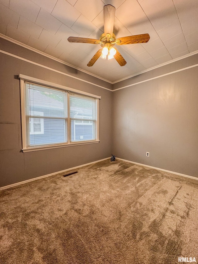 spare room featuring ornamental molding, carpet floors, a ceiling fan, and baseboards