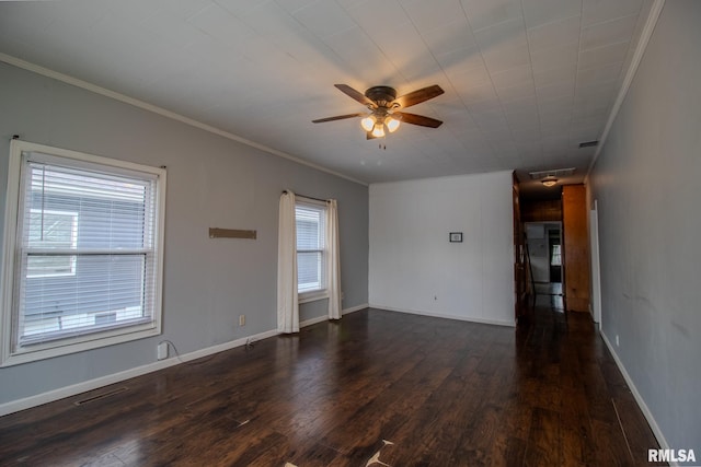 empty room featuring a ceiling fan, dark wood-style flooring, ornamental molding, and baseboards