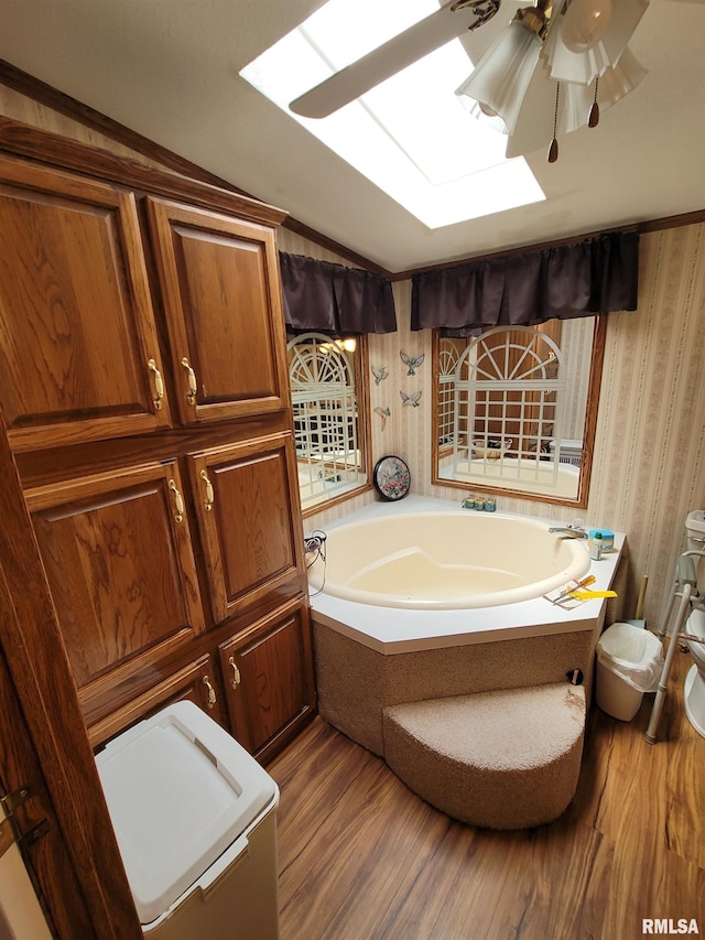 3614 S Hotze Rd, Salem, IL 62881 - bathroom with wallpapered walls, wood finished floors, a garden tub, a skylight, and lofted ceiling