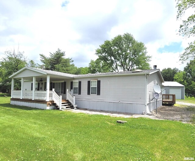 3614 S Hotze Rd, Salem, IL 62881 - manufactured / mobile home featuring covered porch, a front lawn, a garage, and an outbuilding
