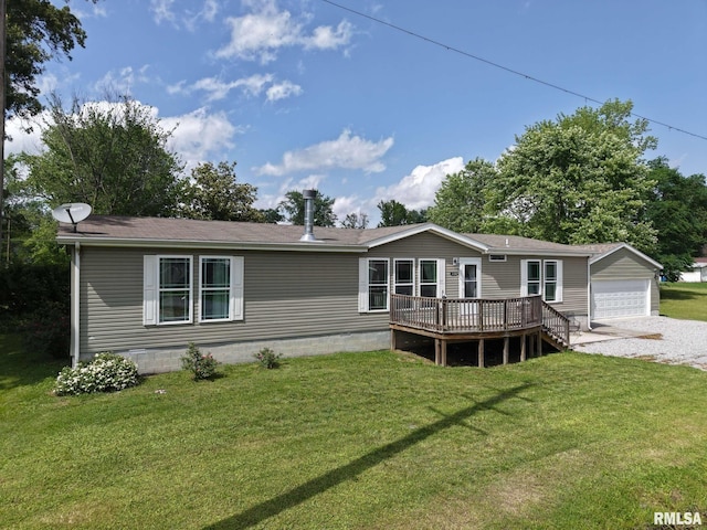 rear view of house with a deck, a yard, a detached garage, a shingled roof, and an outbuilding