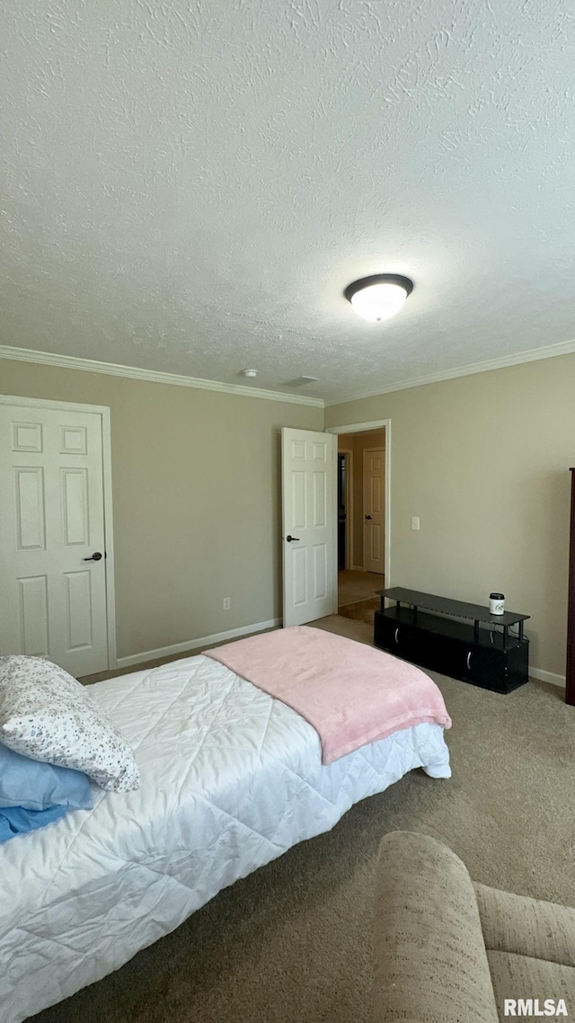 bedroom featuring a textured ceiling, ornamental molding, baseboards, and carpet