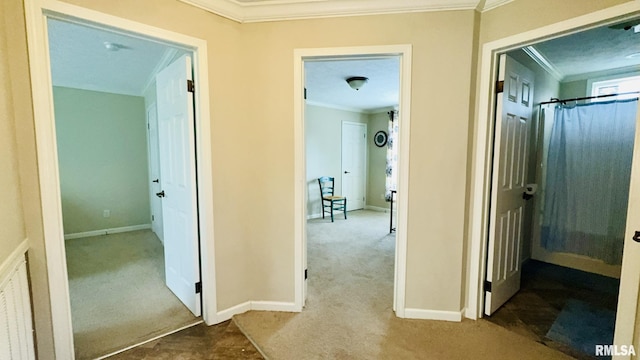 hall featuring carpet floors, crown molding, and baseboards