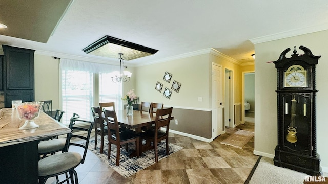 dining space with crown molding, a chandelier, and baseboards