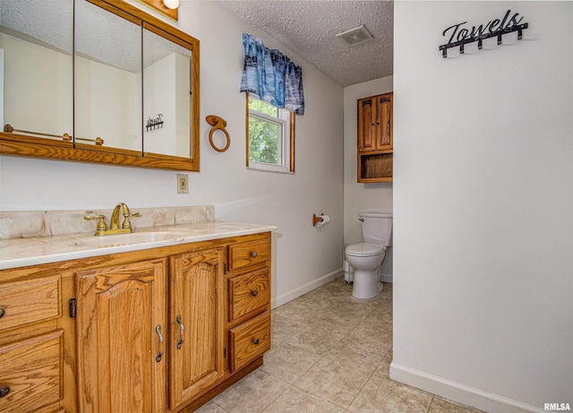 1103 W Boone St, Salem, IL 62881 - bathroom with a textured ceiling, toilet, vanity, baseboards, and tile patterned flooring