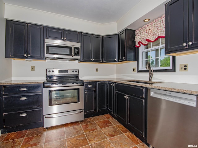 1103 W Boone St, Salem, IL 62881 - kitchen with appliances with stainless steel finishes, a sink, dark cabinetry, dark stone finish floors, and light countertops