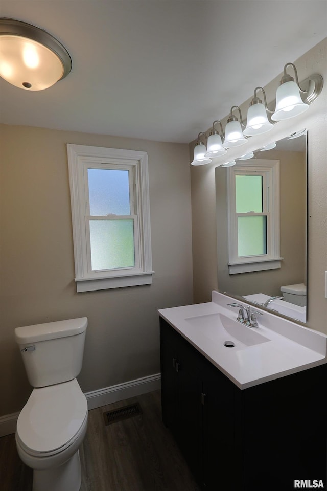 621 E Oglesby, Salem, IL 62881 - half bathroom featuring vanity, toilet, wood finished floors, and baseboards
