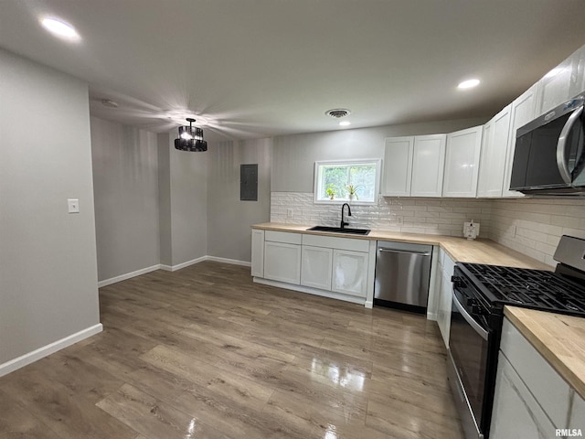 116 Lindsey Ave, Metropolis, IL 62960 - kitchen with stainless steel appliances, a sink, backsplash, white cabinetry, and recessed lighting