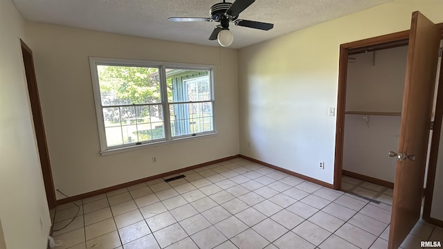 102 Stable Dr, Carterville, IL 62918 - unfurnished bedroom featuring a closet, a textured ceiling, baseboards, a ceiling fan, and light tile patterned flooring