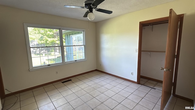 102 Stable Dr, Carterville, IL 62918 - unfurnished bedroom with a textured ceiling, a closet, baseboards, and a ceiling fan