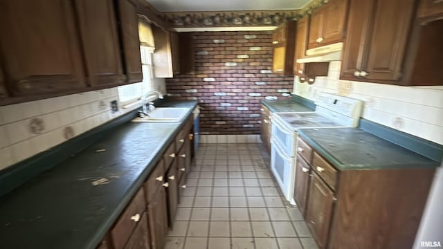102 Stable Dr, Carterville, IL 62918 - kitchen with electric stove, light tile patterned floors, a sink, under cabinet range hood, and dark countertops