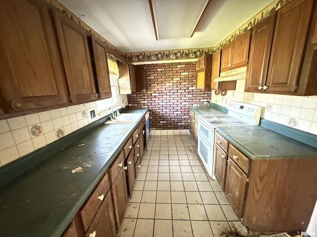 102 Stable Dr, Carterville, IL 62918 - kitchen with range with two ovens, a sink, under cabinet range hood, tasteful backsplash, and dark countertops