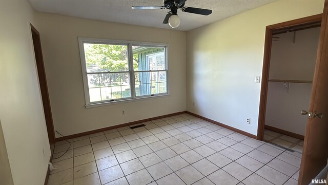 102 Stable Dr, Carterville, IL 62918 - unfurnished room with ceiling fan, baseboards, light tile patterned floors, and a textured ceiling