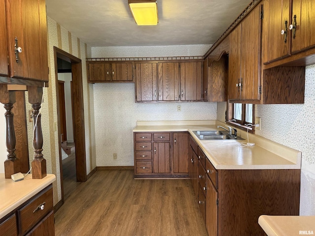 19 Park Ln, Centralia, IL 62801 - kitchen featuring wallpapered walls, a sink, dark wood finished floors, light countertops, and brown cabinets