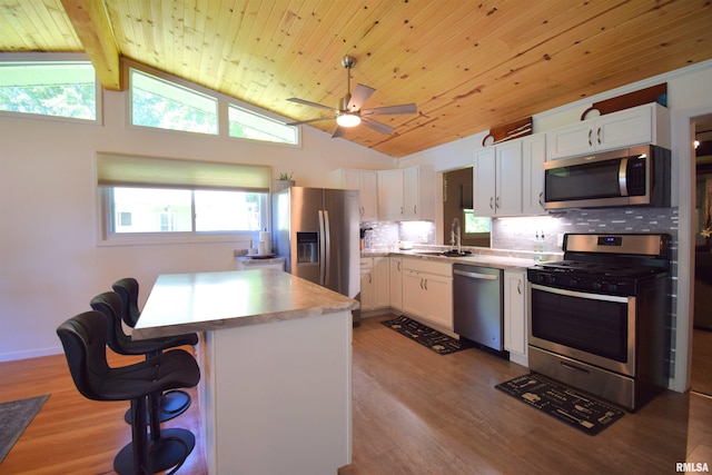 2704 Jamison Blvd, Mount Vernon, IL 62864 - kitchen featuring stainless steel appliances, light wood-style floors, vaulted ceiling, white cabinetry, and a sink