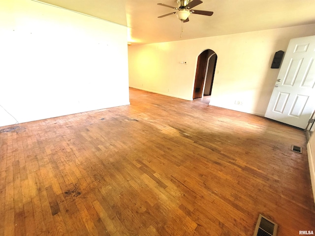 422 E Dr, Flora, IL 62839 - empty room featuring arched walkways, ceiling fan, and light wood-style flooring