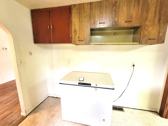 422 E Dr, Flora, IL 62839 - kitchen featuring arched walkways, baseboards, and brown cabinetry