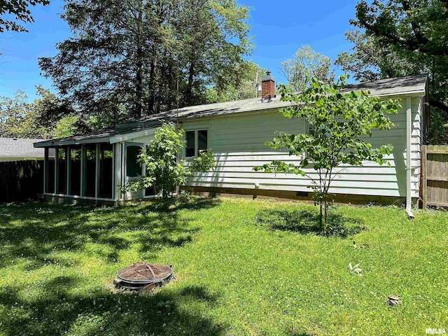 504 S James St, Carbondale, IL 62901 - rear view of property featuring a fire pit, a sunroom, and a chimney