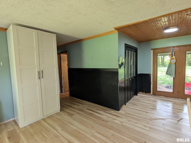 8271 Pigg Ln, Thompsonville, IL 62896 - foyer featuring light wood-style floors, a wainscoted wall, ornamental molding, and a textured ceiling
