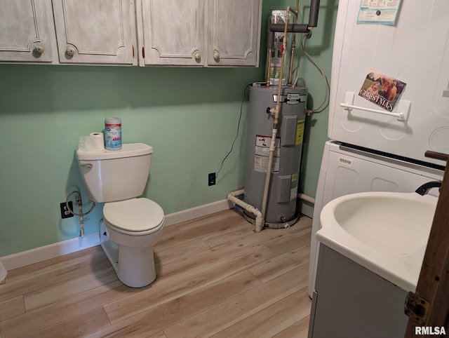 8271 Pigg Ln, Thompsonville, IL 62896 - half bathroom with water heater, toilet, wood finished floors, vanity, and baseboards