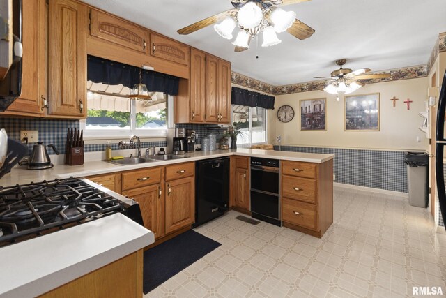 49 Jon St, Metropolis, IL 62960 - kitchen featuring black dishwasher, a sink, a peninsula, a ceiling fan, and wainscoting