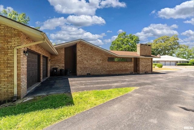 415 E Reichert Dr, Marion, IL 62959 - view of property exterior with brick siding, a chimney, and a garage