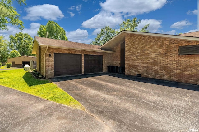 415 E Reichert Dr, Marion, IL 62959 - view of home's exterior with brick siding, a garage, asphalt driveway, a yard, and a shingled roof