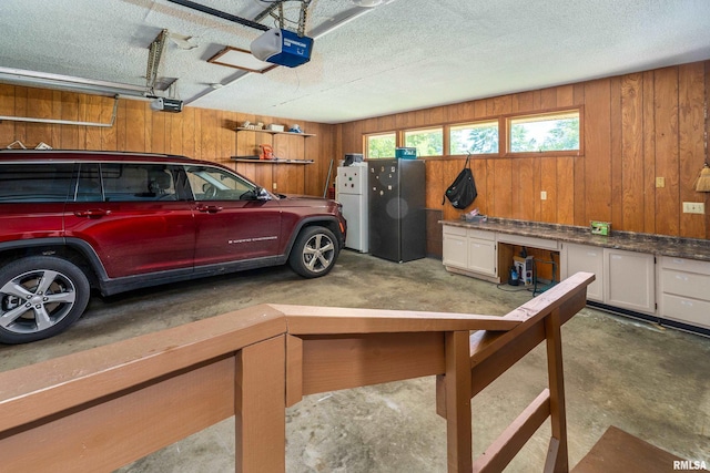 415 E Reichert Dr, Marion, IL 62959 - garage with a garage door opener, wood walls, and freestanding refrigerator