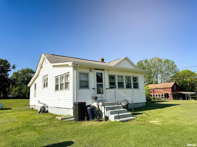 135 Walnut St, Alto Pass, IL 62905 - rear view of house featuring entry steps, a lawn, a chimney, and roof with shingles