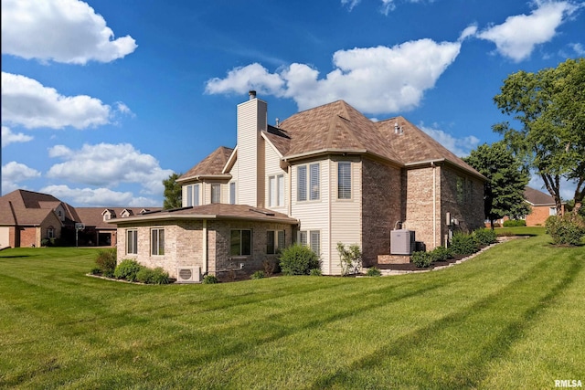 1302 Collins Ln, Marion, IL 62959 - rear view of property with brick siding, a lawn, a chimney, and a cooling unit
