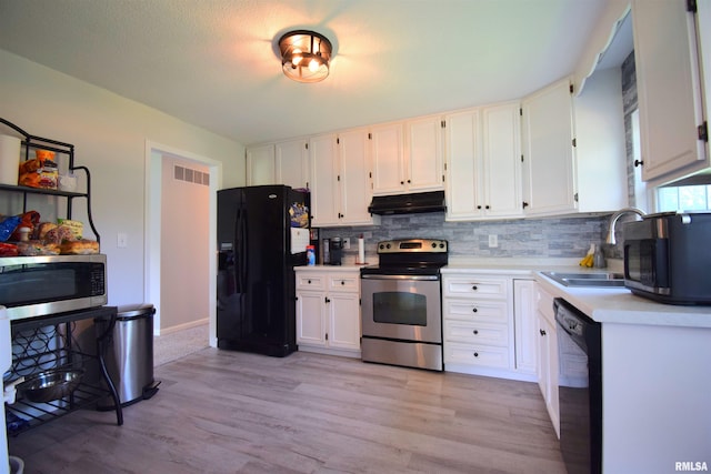 3100 Mulberry Ave, Mount Vernon, IL 62864 - kitchen with black appliances, under cabinet range hood, light countertops, decorative backsplash, and light wood-style flooring