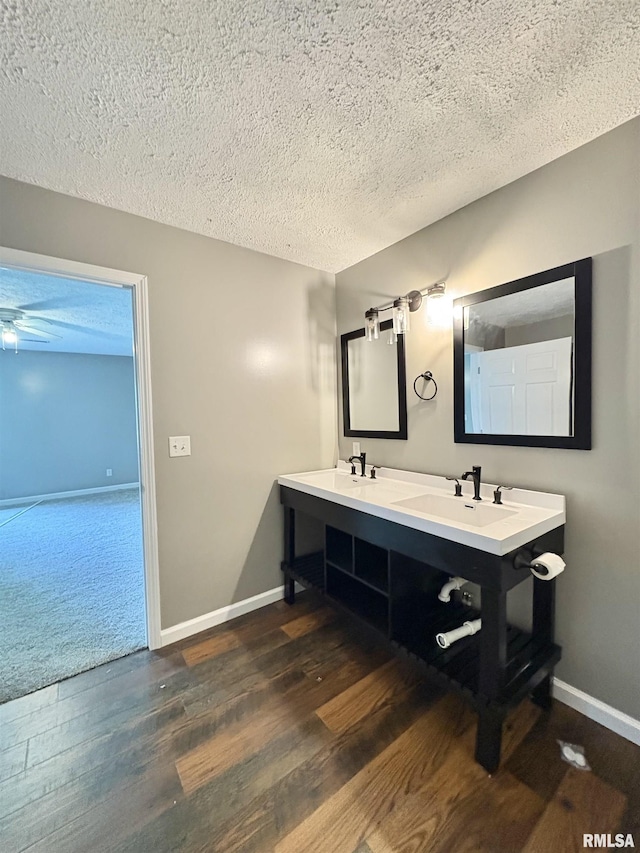 910 Fairlane Dr, Marion, IL 62959 - bathroom with a textured ceiling, wood finished floors, baseboards, and double vanity