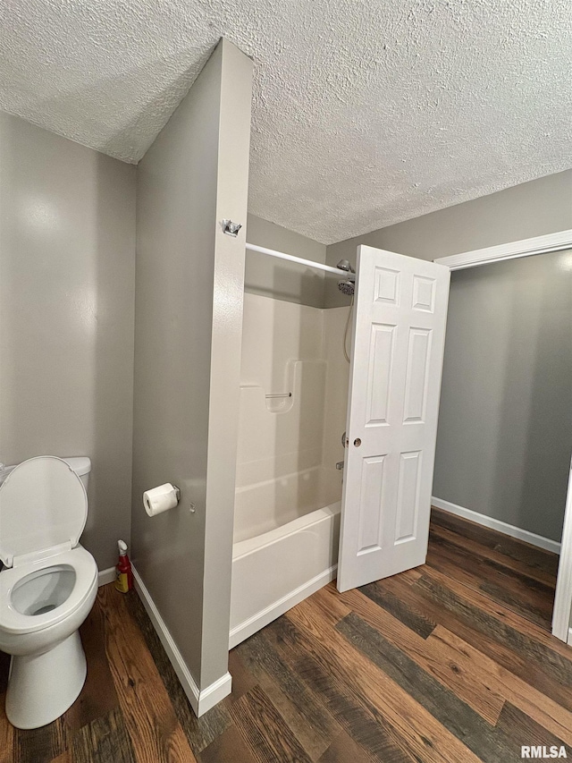 910 Fairlane Dr, Marion, IL 62959 - full bathroom with a textured ceiling, toilet, wood finished floors,  shower combination, and baseboards