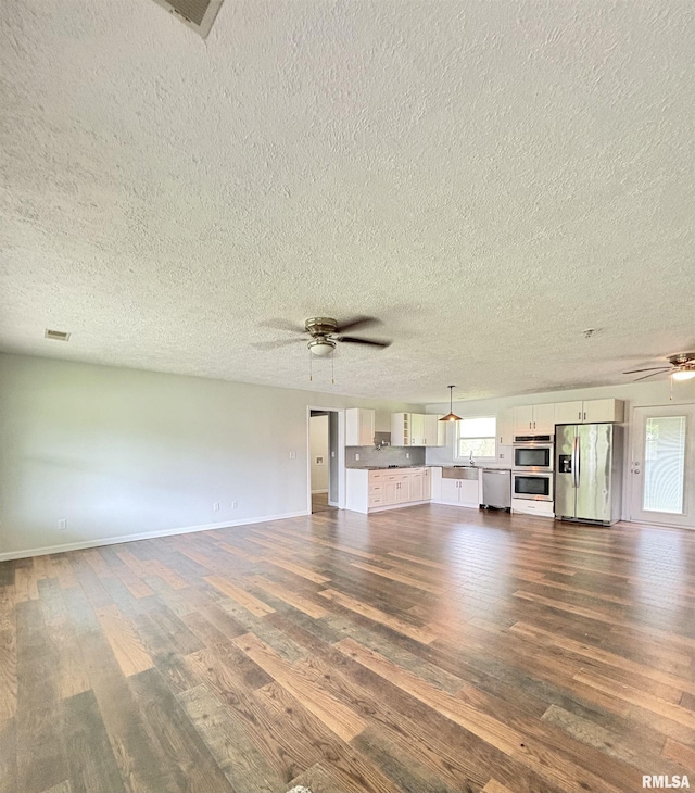 910 Fairlane Dr, Marion, IL 62959 - unfurnished living room featuring a ceiling fan, dark wood-style flooring, a textured ceiling, and baseboards